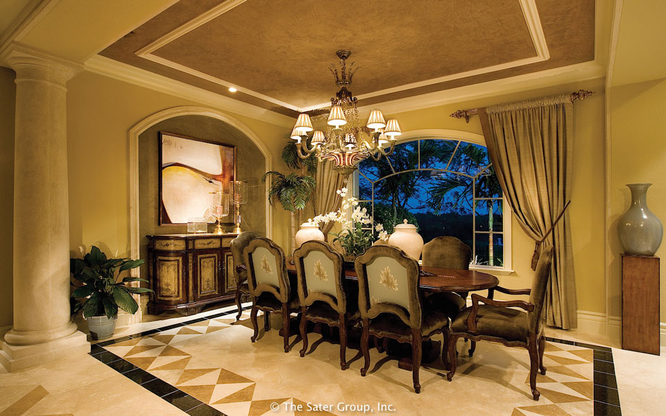 The formal dining area has a tray ceiling and arched window.