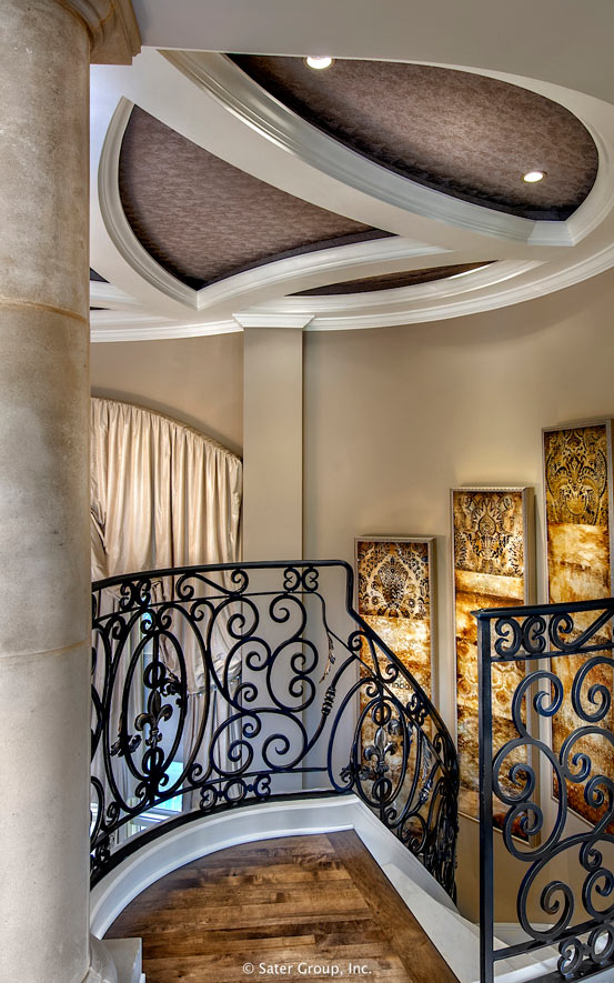 The top of the spiral staircase has richly decorated railings and ceiling.